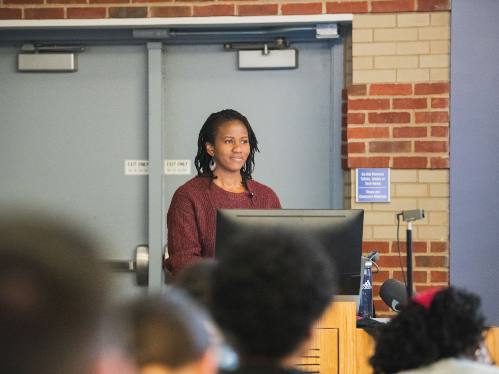 Person stands behind a monitor at a podium