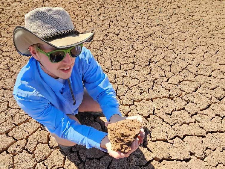 Student examines soil in New Mexico
