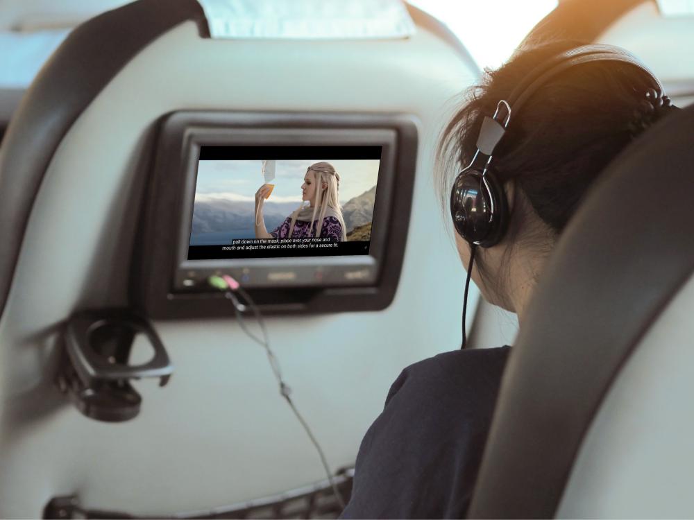 Person on an airplane watches a "Lord of the Rings"-themed safety video on a monitor