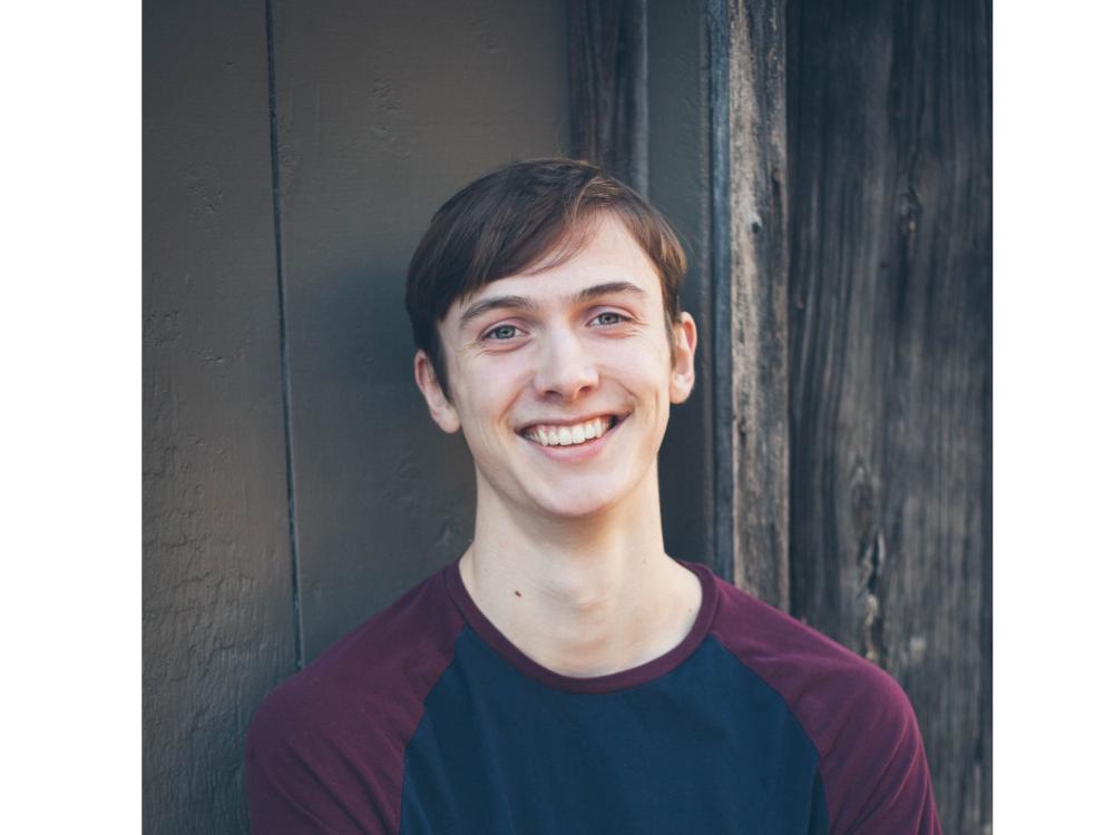headshot of smiling person with short dark hair