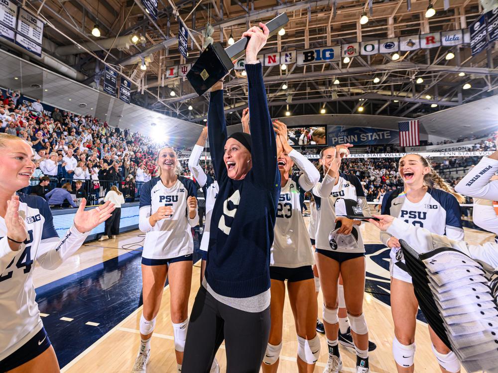 Schumacher-Cawley celebrates by raising trophy with her team
