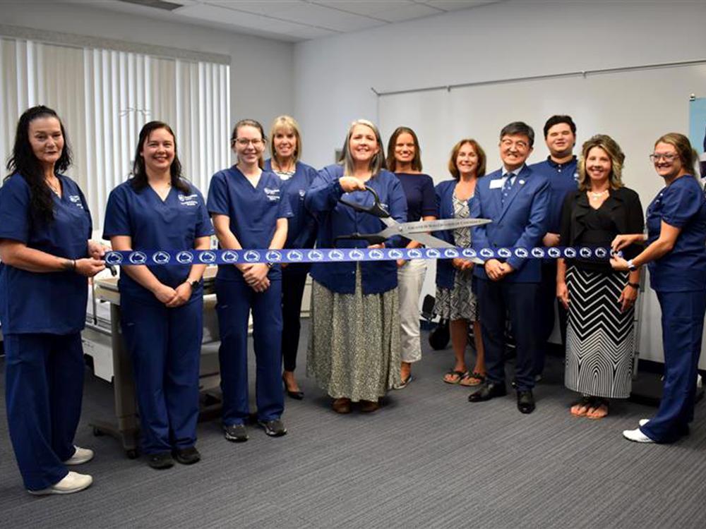Nicki Dufour, PN Program Coordinator, prepares to cut the ribbon during the ribbon cutting ceremony for the Practical Nursing program at Penn State DuBois. Dufour was joined by students and instructors in the program, as well as other campus and community members.