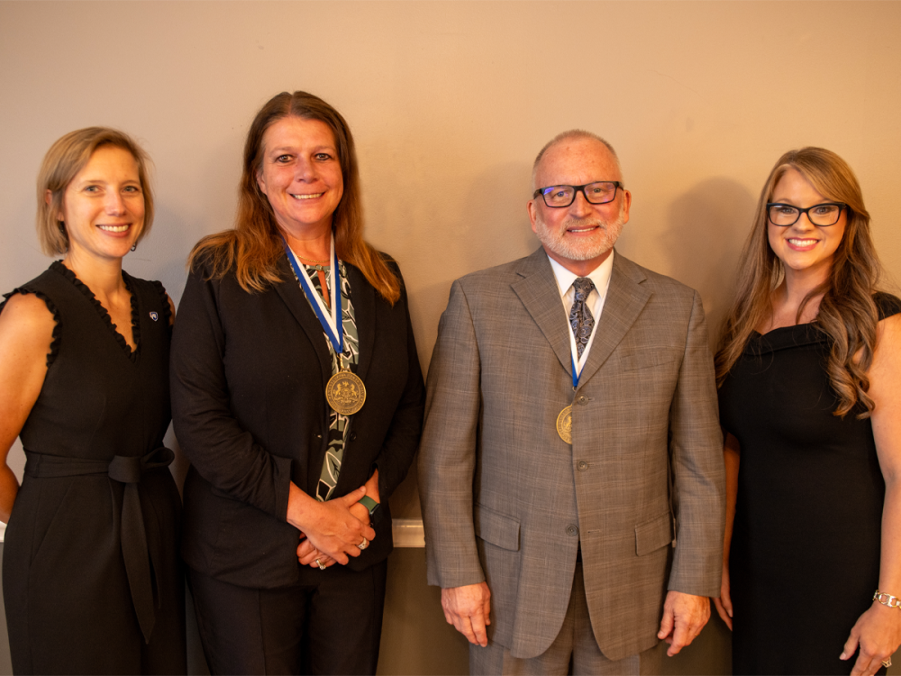 Megan Nagel, Rachel Duda, W. Charles Patrick, and Tiffany Guittap stand together at the 2025 Penn State Fayette Advisory Board meeting, where Duda and Patrick were honored as the Alumna and Outstanding Fellow award recipients.