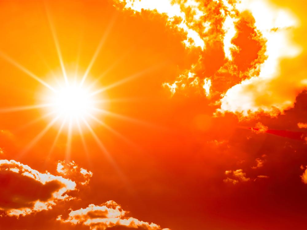 A very hot red sun shines in the sky during a heatwave.