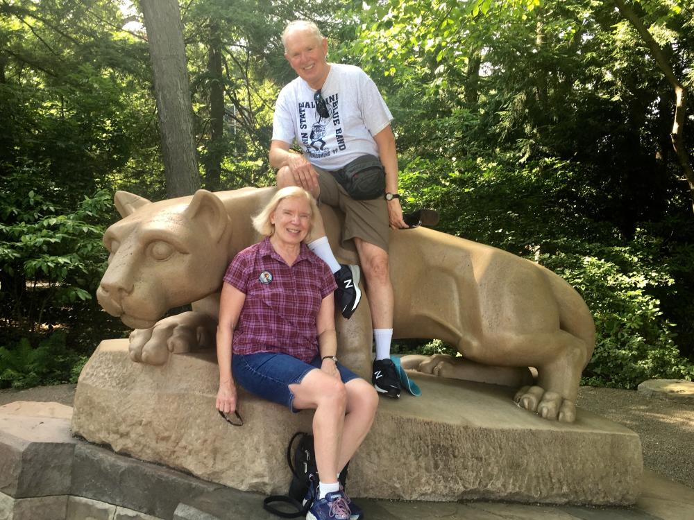 A couple poses for a photo at the Nittany Lion Shrine at Penn State.