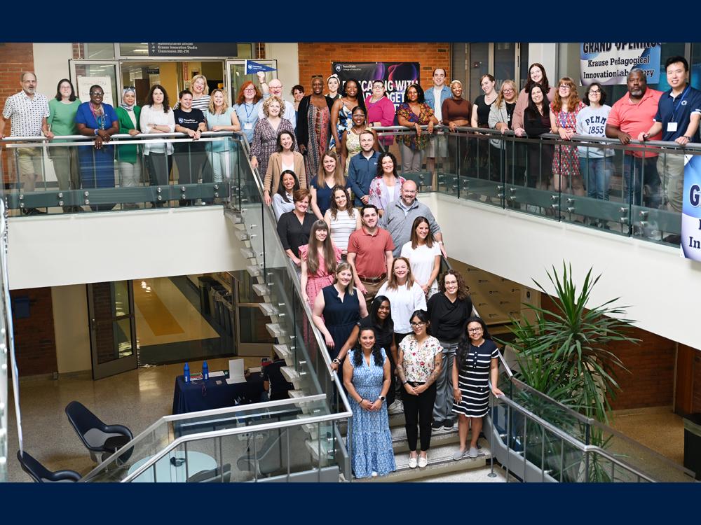 The Summer Summit attendees pose with faculty and staff for a group photo on and around a staircase.