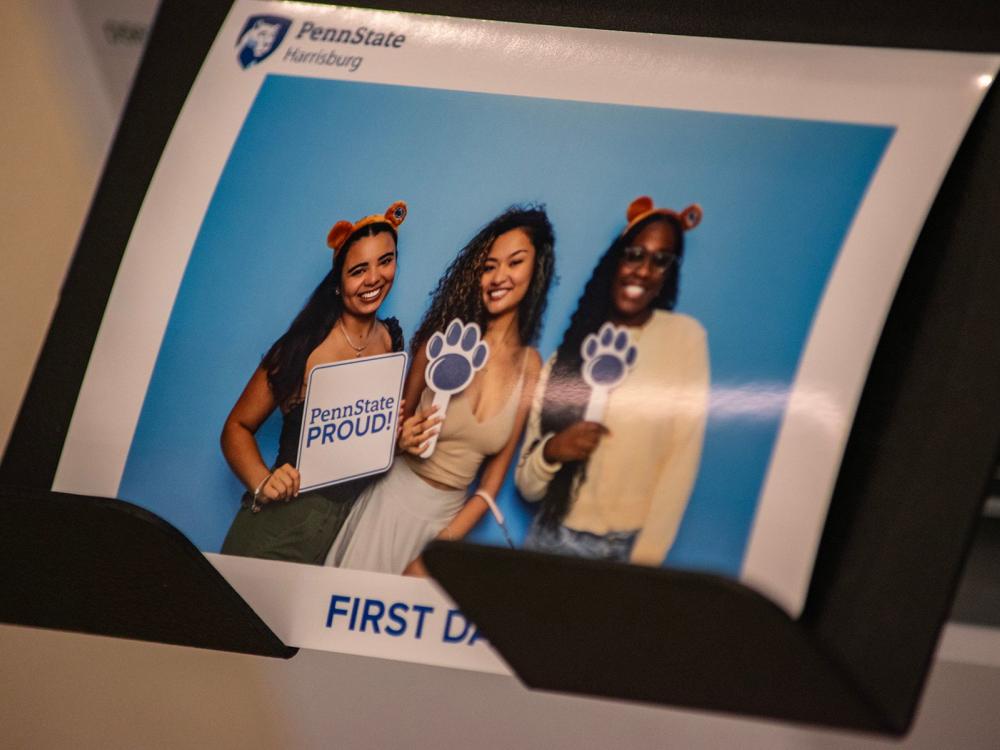 A picture of an instant-print photograph showing three students at Penn State Harrisburg