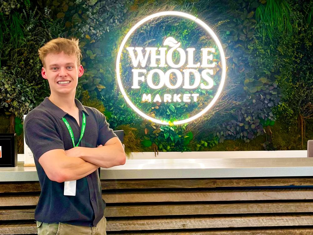 Ben Lindgren stands in front of the Whole Foods Market logo at company headquarters in Austin, Texas.