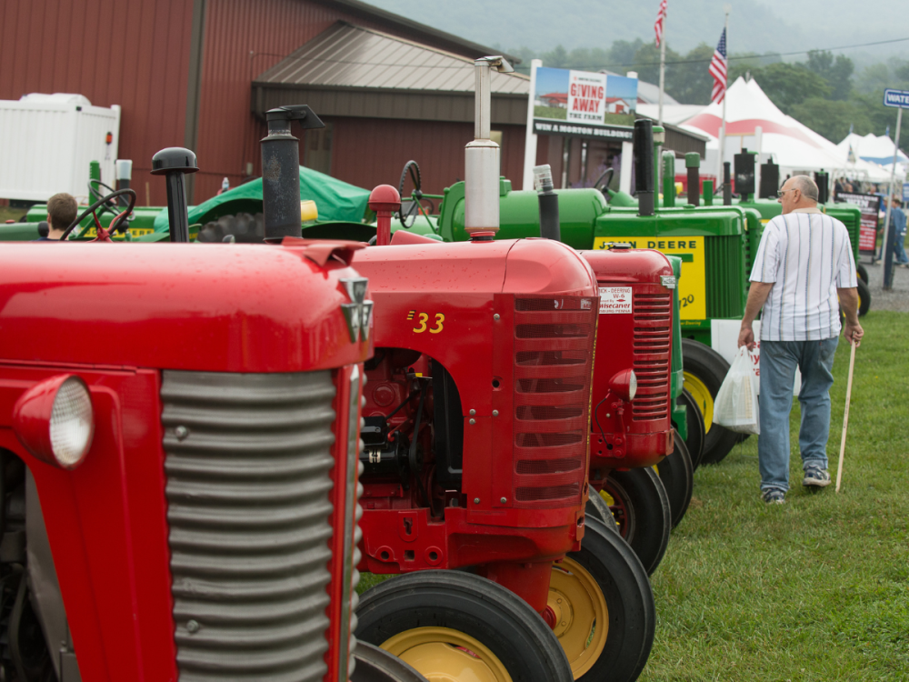 People walking next to a line of tractors at Ag Progress Days