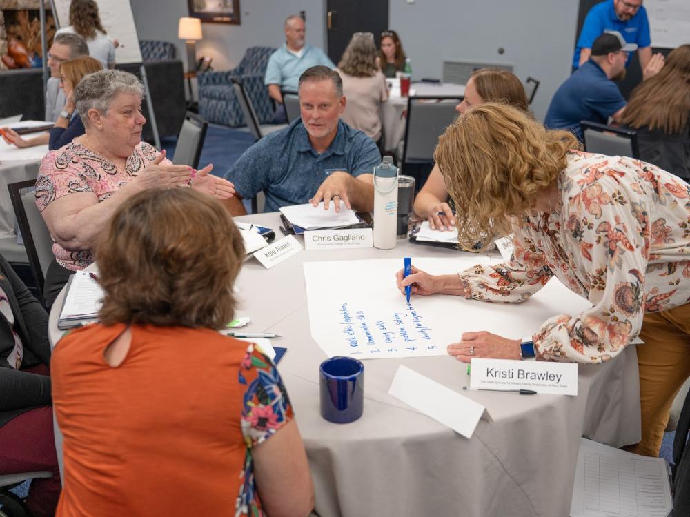 A group of people work together around a table