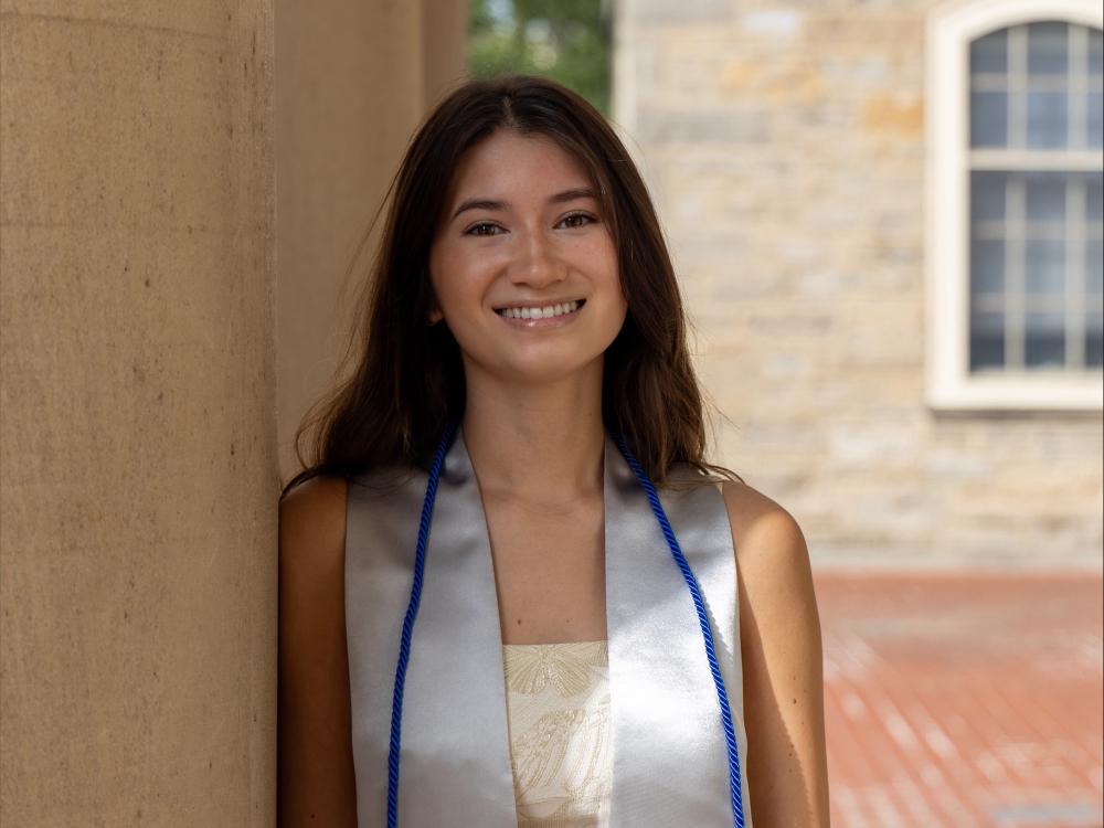 Emma Suzuki Szwajkowski stands outside the main entrance of Old Main at Penn State University Park.