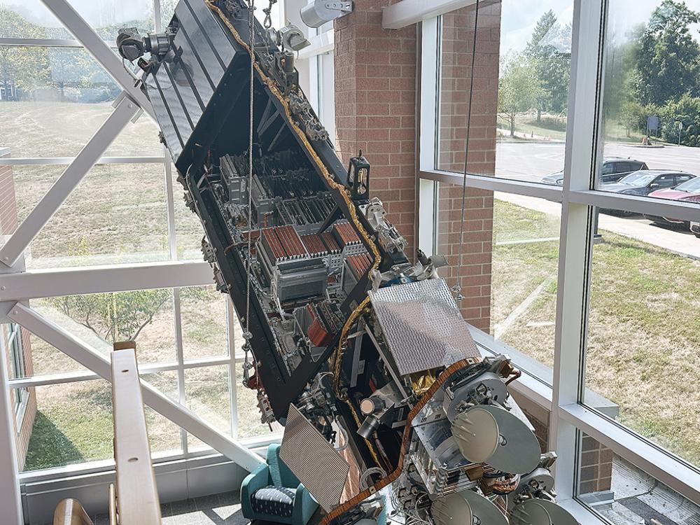 A photo of a communications satellite hanging from the ceiling of an atrium