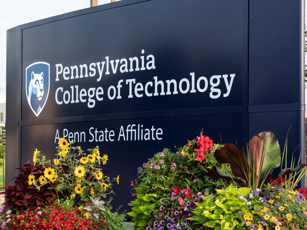 Flowers planted at the base of the Pennsylvania College of Technology welcome sign