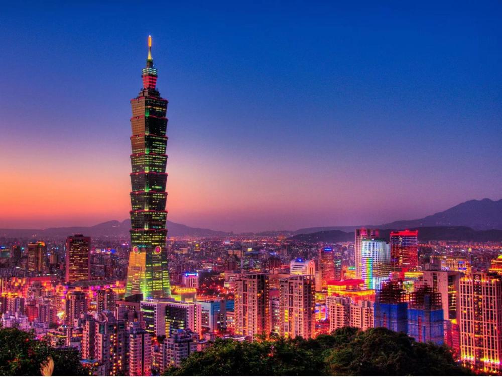 A large skyscraper amid a backdrop of a purple sunset