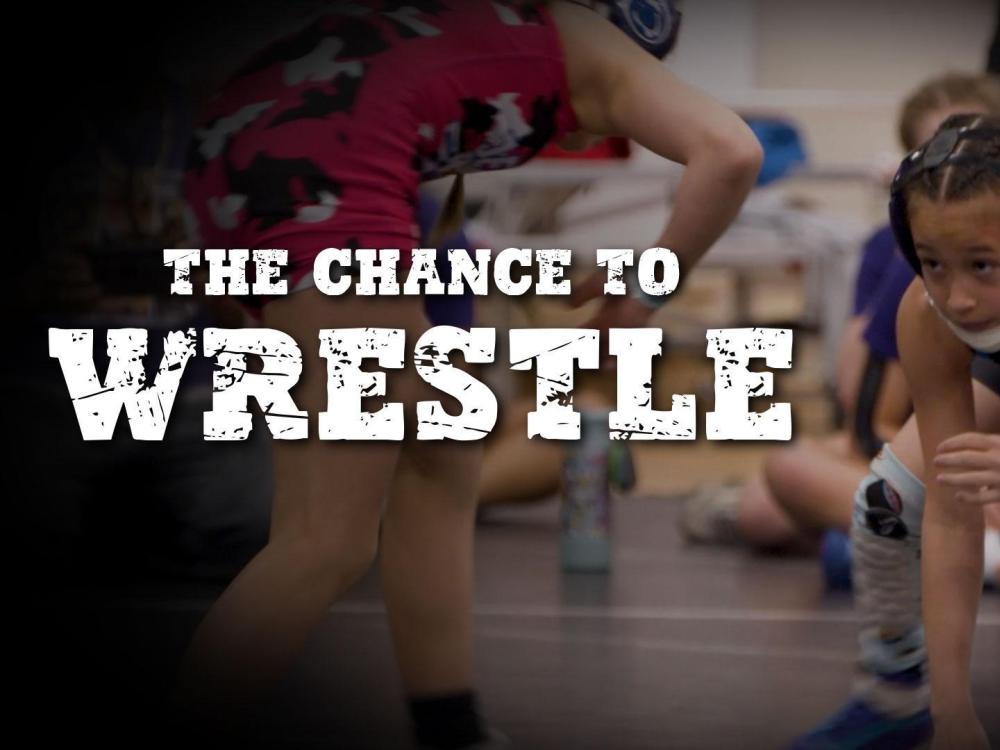 Female wrestlers on the mat during a match.