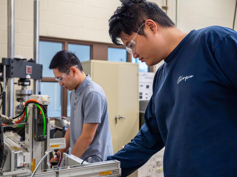 People standing in a lab in front of machinery looking like researchers