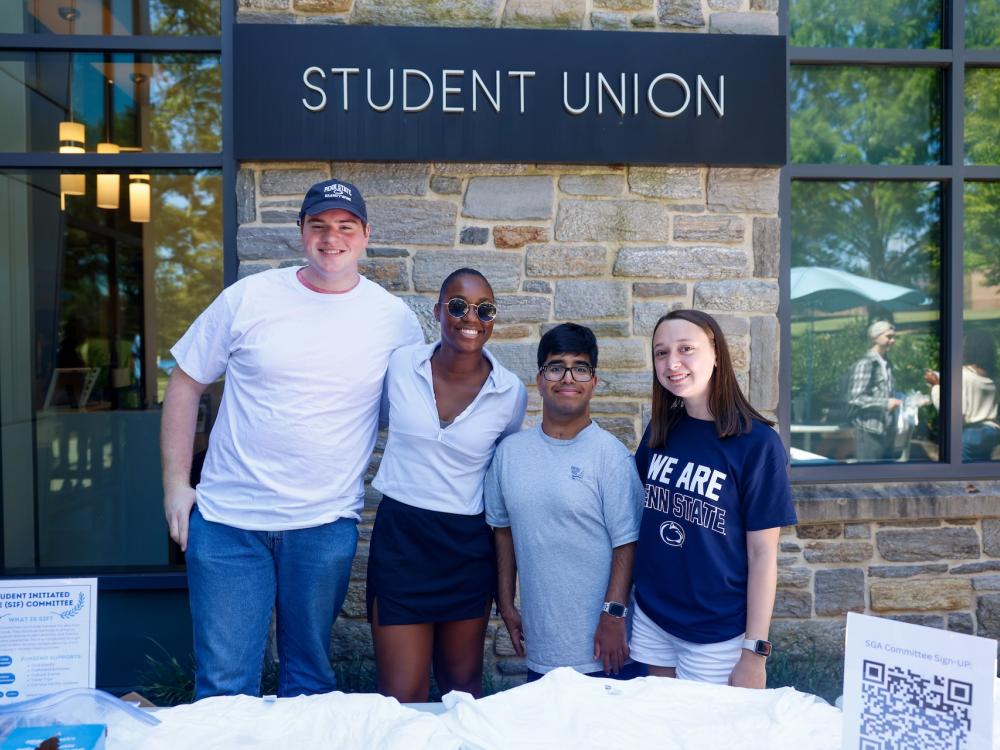 Tim McClure, Maddie Ferguson, Tejas Chigurupati and Sara Hallahan posing for a photo in front of the Student Union at an event during Week of Welcome