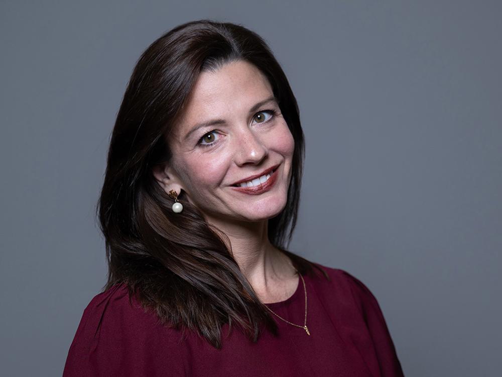 Smiling dark haired person in a red top