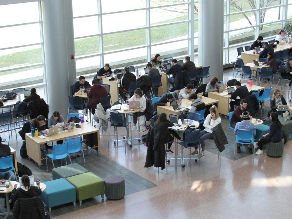 A photo from above the Dr. Keiko Miwa Ross Atrium in Penn State's Business Building shows students sitting and studying at tables.