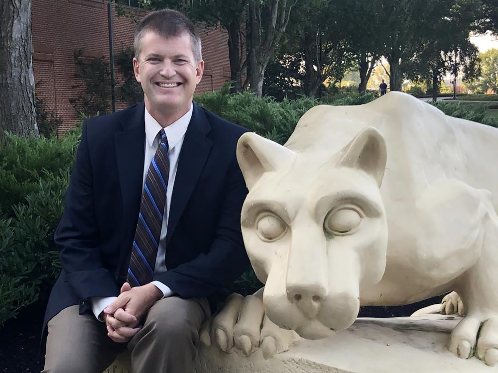 Todd Clark with the Lion statue at Penn State Harrisburg