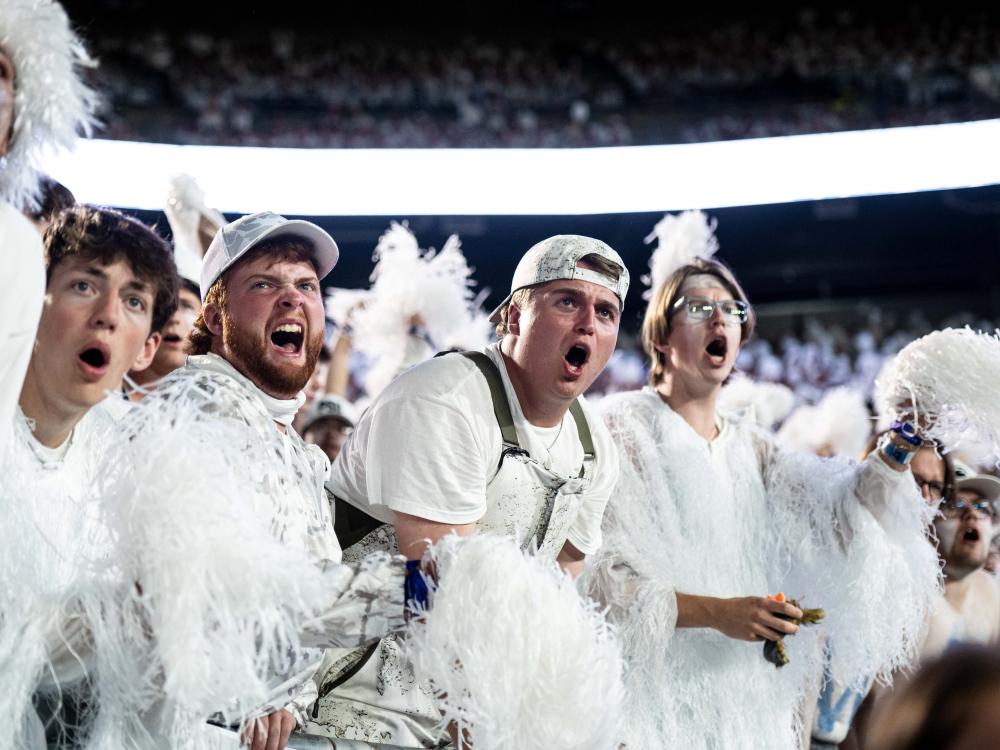 People yelling in student section during a football game