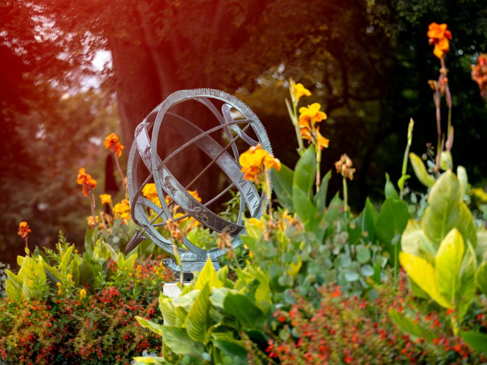 The armillary sphere on Penn State's Unviersity Park campus surrounded by colorful plants