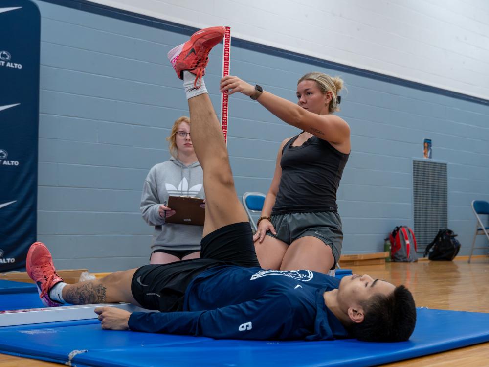 A student-athlete completes a leg raise as part of a pre-season Functional Movement Screening