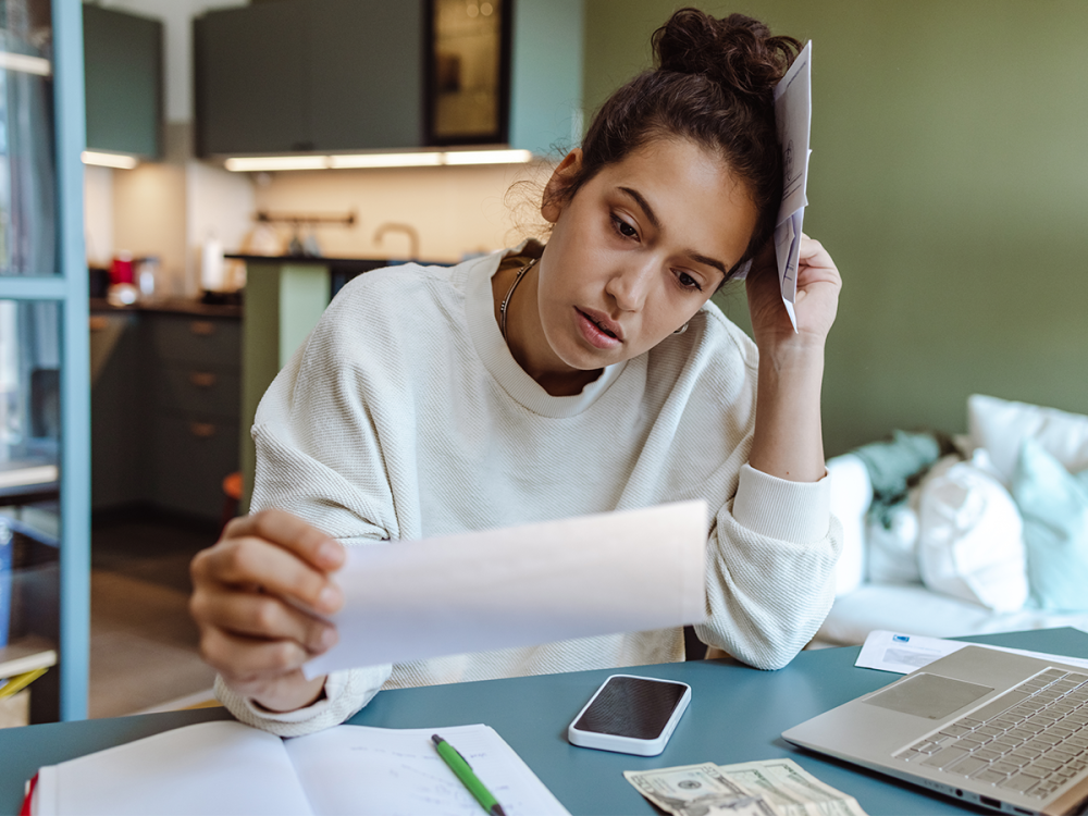 concerned person sitting at desk looking at a paper