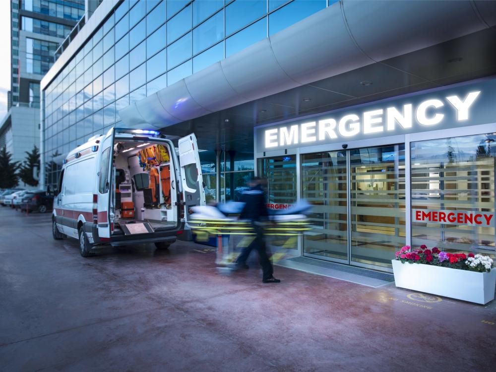 Paramedics taking patient on stretcher from ambulance to hospital