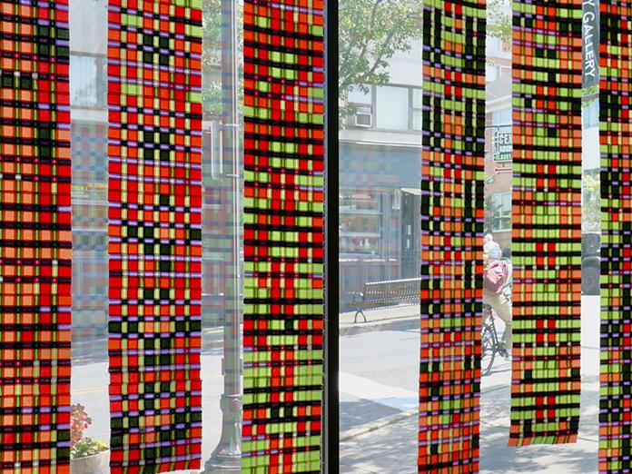 Multicolored tapestry made with small colorful squares installed in a linear pattern