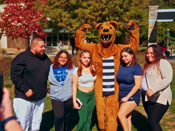 Family poses with the Nittany Lion at Homecoming