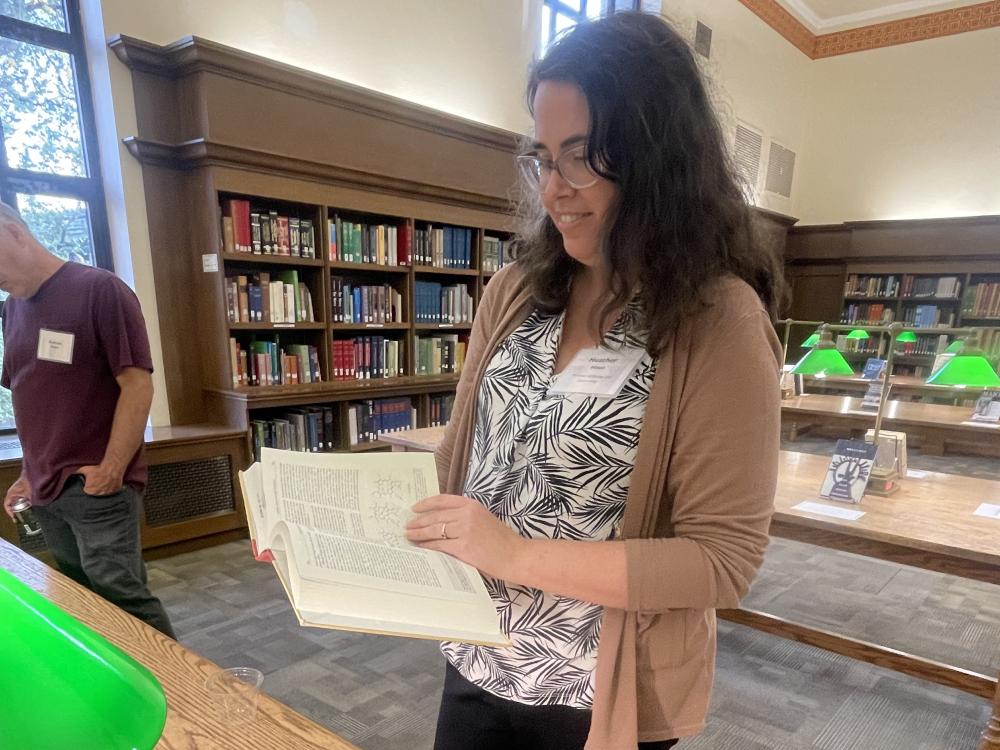 A guest at the 2025 Promotion and Tenure Reception looking at a book selection.