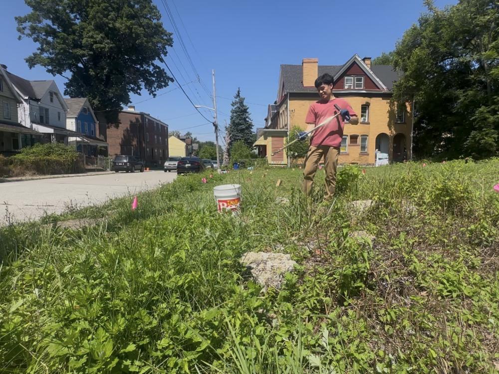 Student working in a garden on a green space lot located on a city block