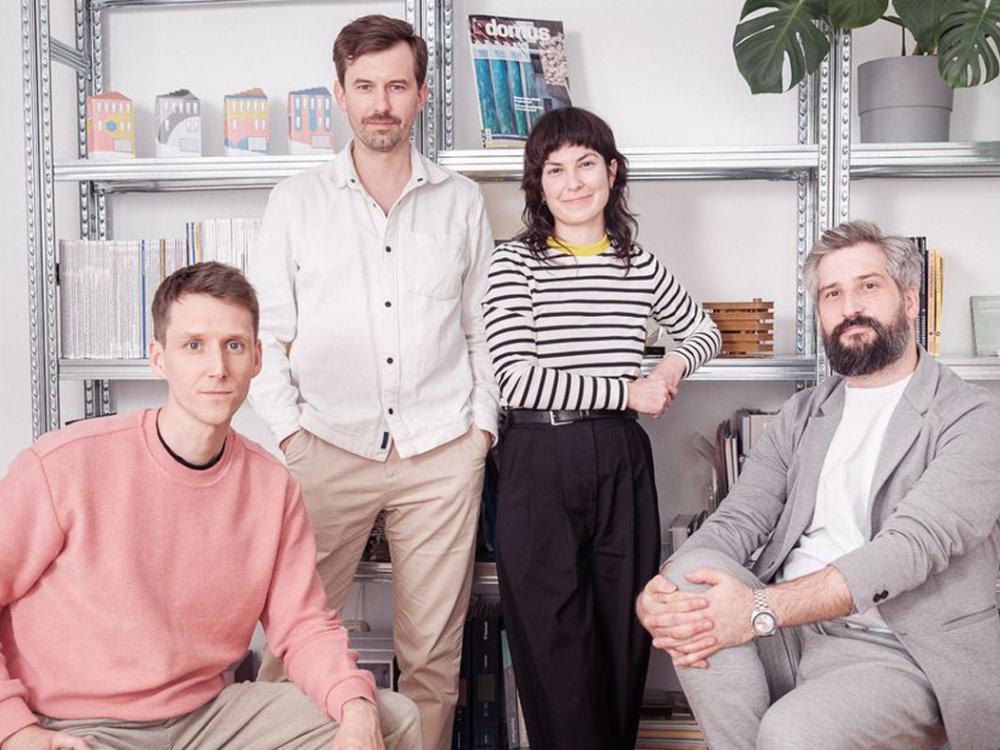 Portrait of four people in front of a bookshelf.