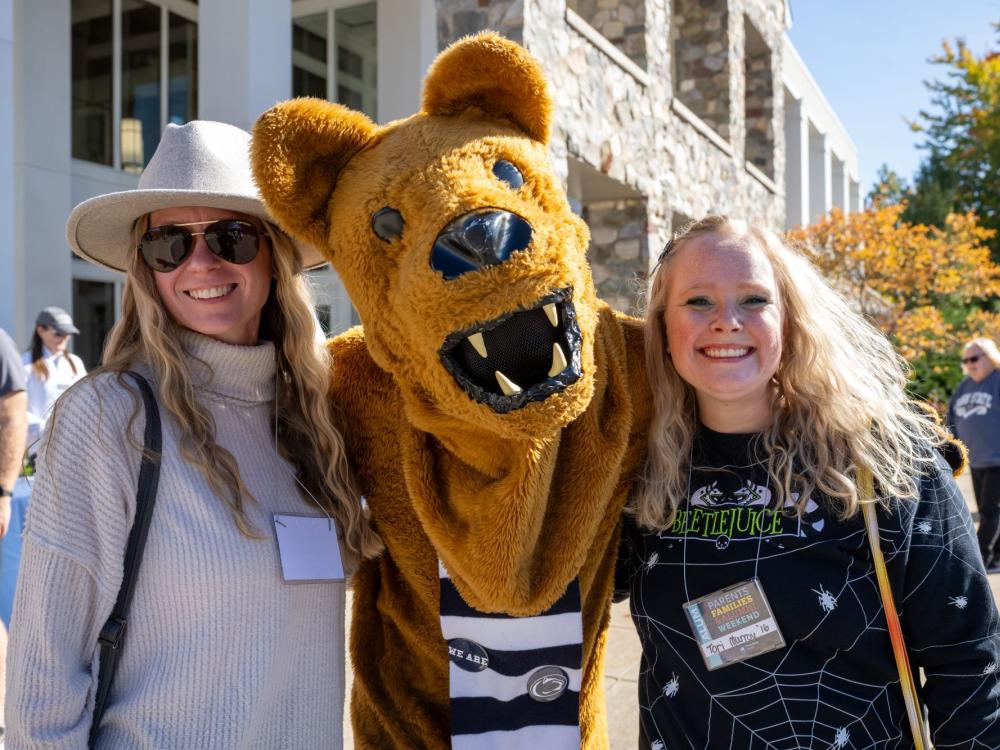 Two women pose with the Nittany Lion at Penn State Behrend's Parents, Families, and Alumni Weekend.