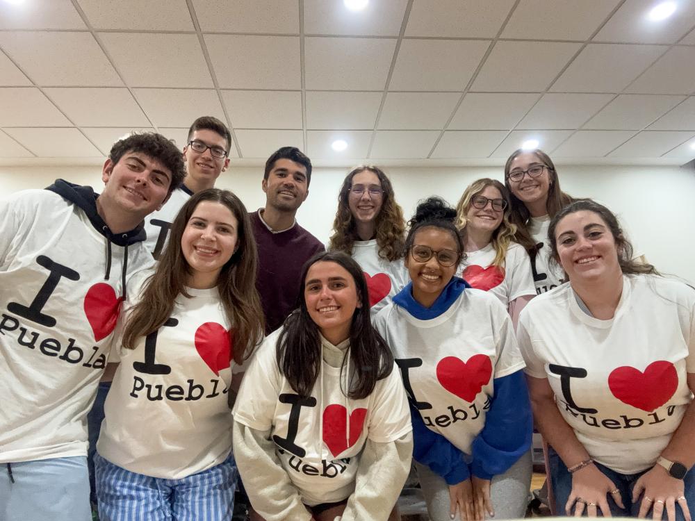 Students in the Spanish Language and Mexican Culture faculty-led course wear matching white t-shirts with hearts on them. They are accompanied by Lecturer of Spanish Daniel Sanguino.