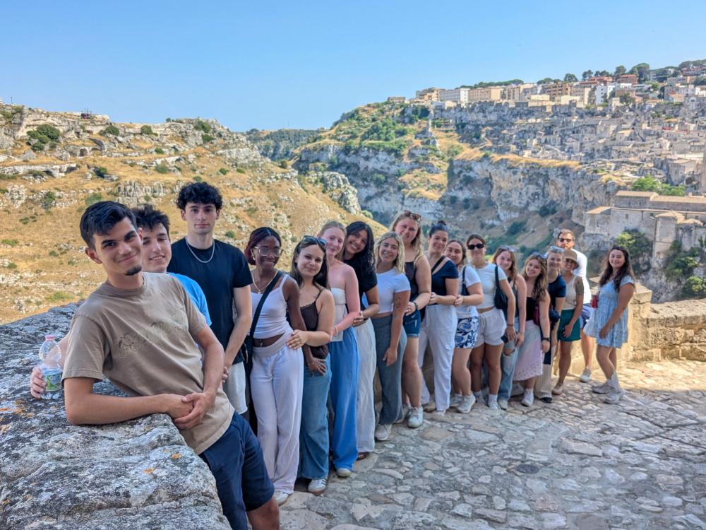 Penn State students stand in a line along a stone wall in Matera, Italy.