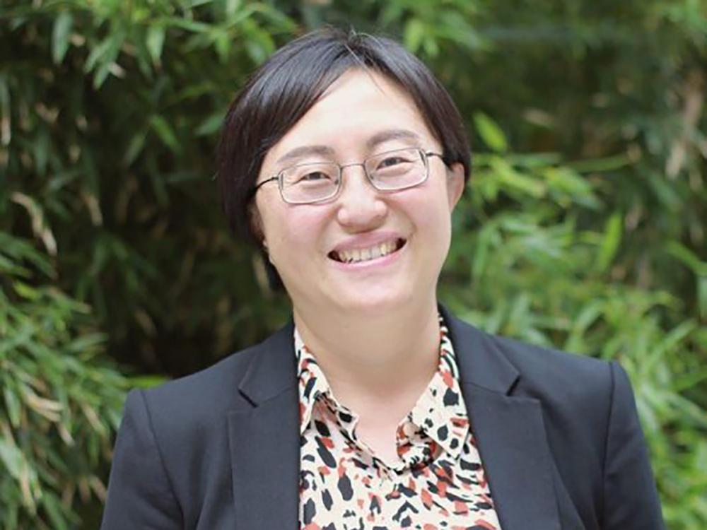 A head and shoulders photo of a smiling Siqi Zheng.