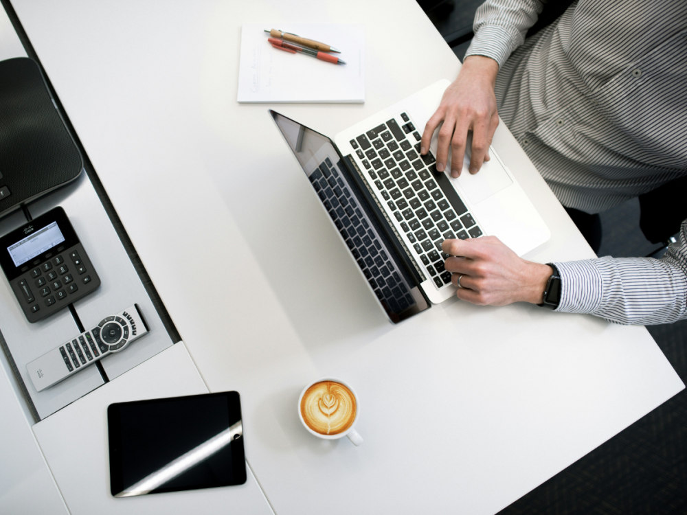 Photo of hands typing on a laptop on a desk