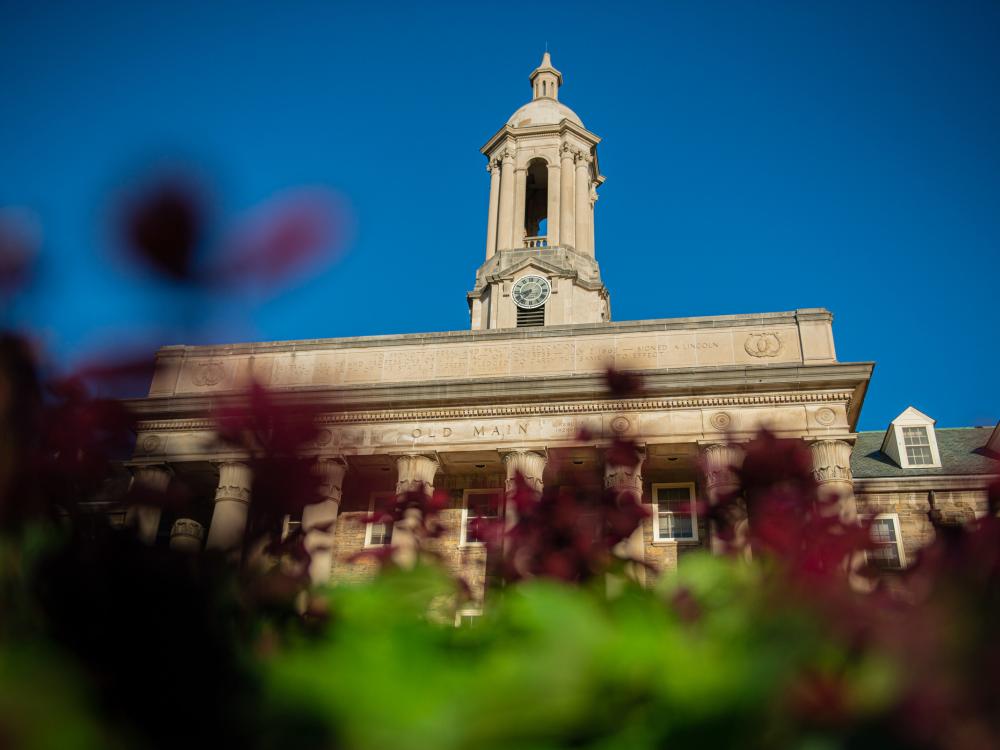 Photograph of Old Main building with fall foliage in the foreground