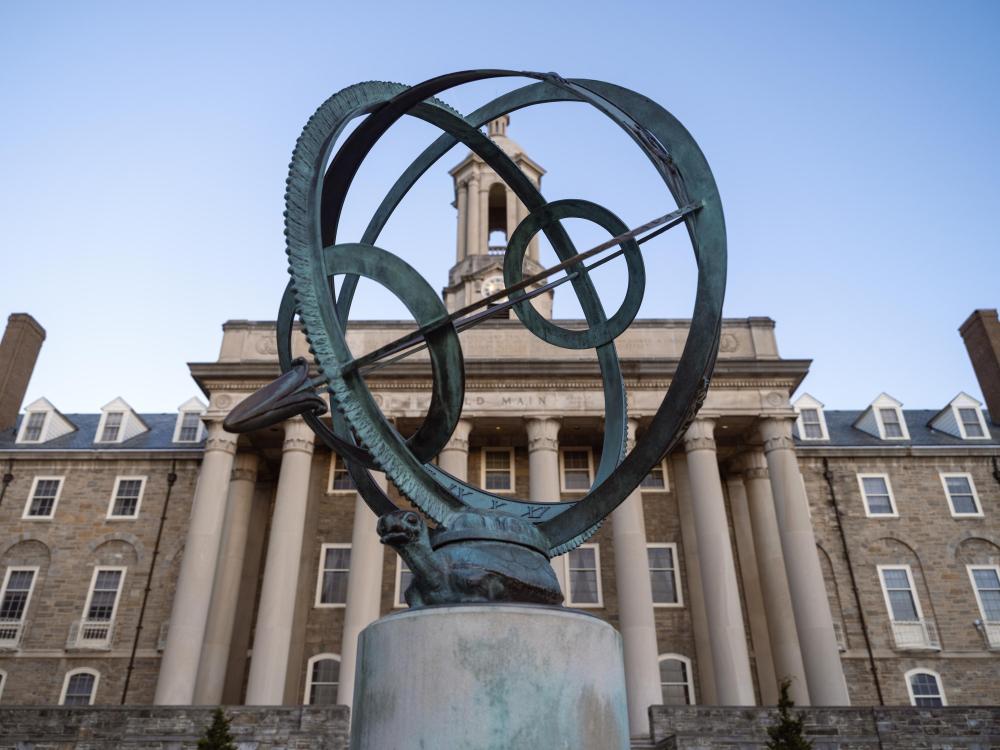 Photo of armillary sculpture and Old Main building