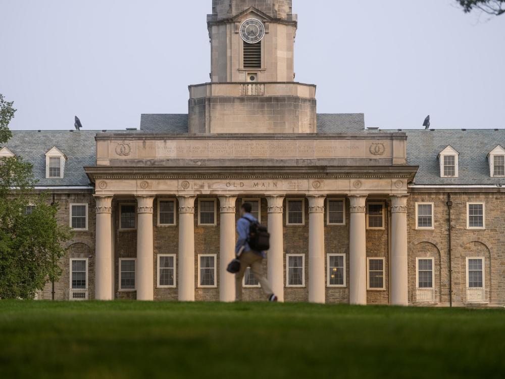 Old Main building with person walking in foreground