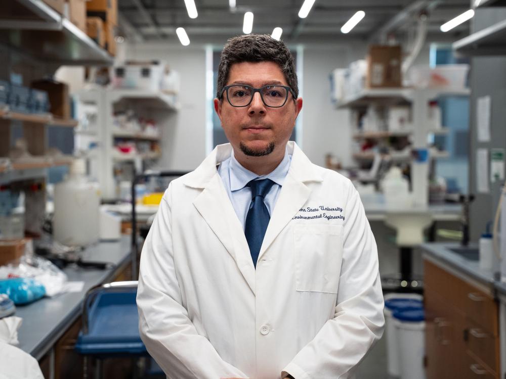 Portrait of Onur Apul in a white lab coat
