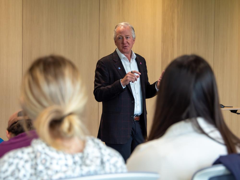 Person standing in front of a crowd of people talking about the options available at Saint-Gobain North America.