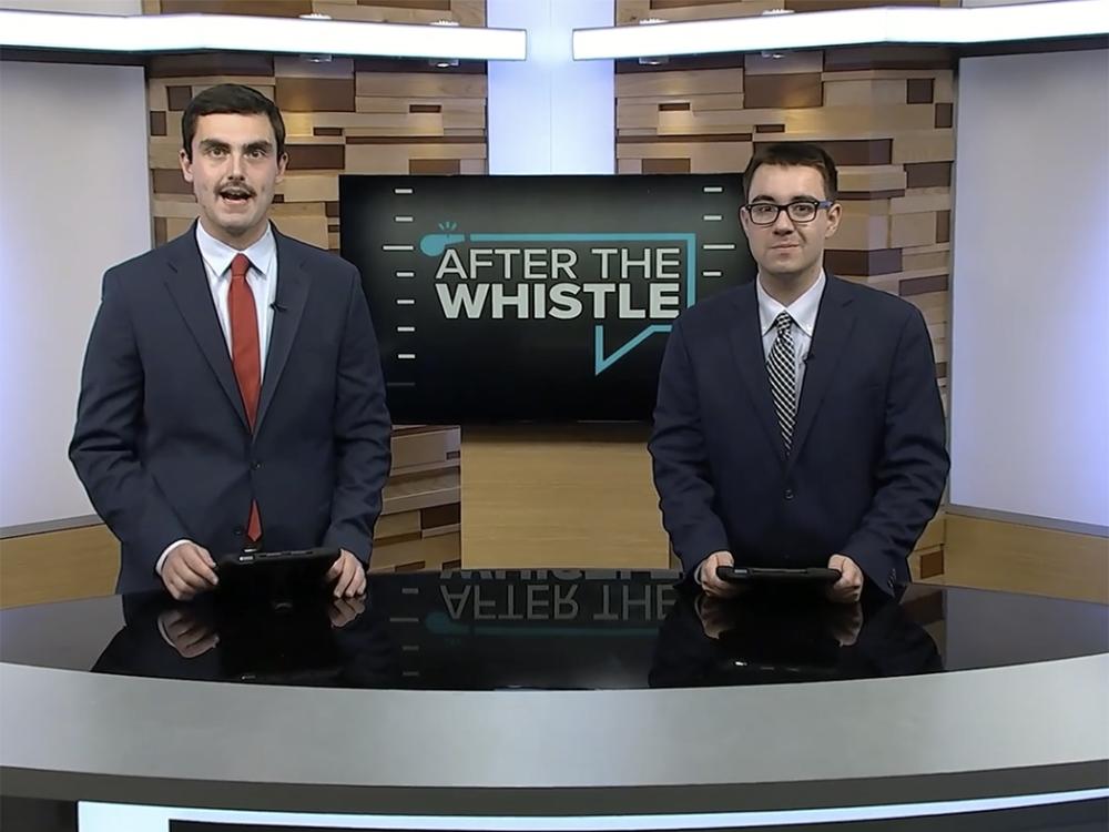 Two coat-and-tie students on a TV studio set