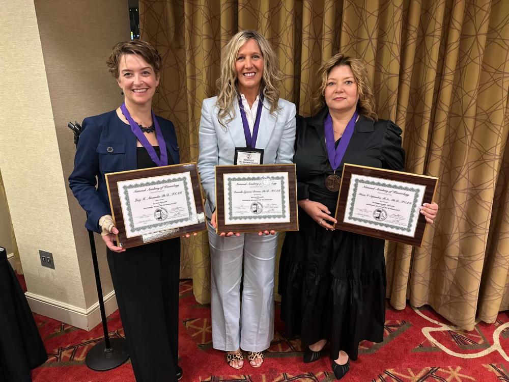 Lacy Alexander and Danielle Symons Downs pictured with another NAK fellow, Alison September, all holding certificates.