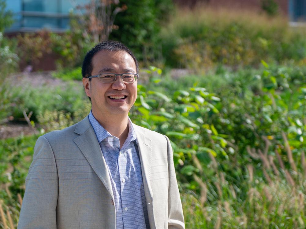 Man standing in front of green foliage