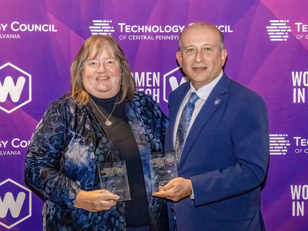 Shirley Clark and Vahid Motevalli pose holding awards