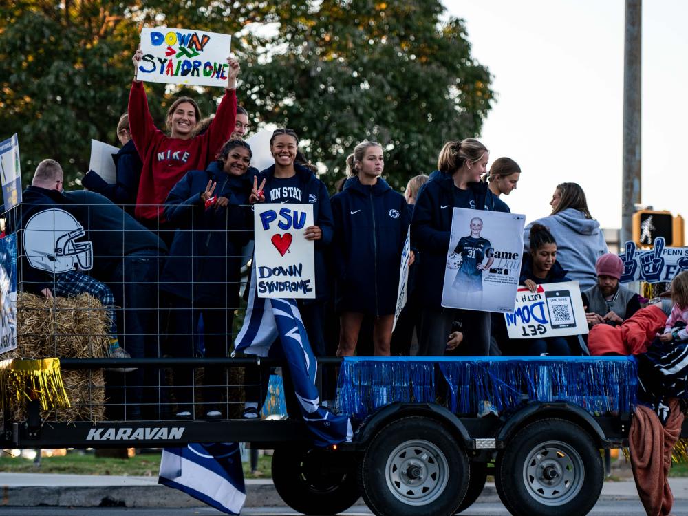 People on a homecoming float waving and smiling