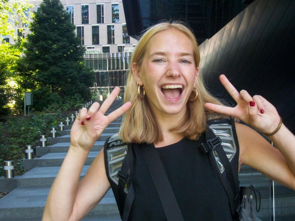 Katie Dallas stands outside of the Nike World Headquarters in Beaverton, Oregon, flashing two peace signs.